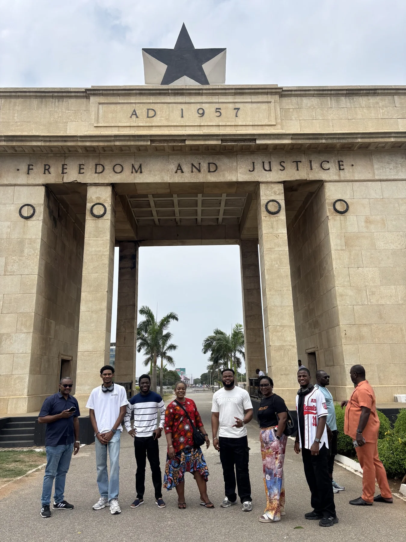 A cohort at the Independence Arch in Accra, Ghana, inscribed Freedom and Justice, AD 1957.