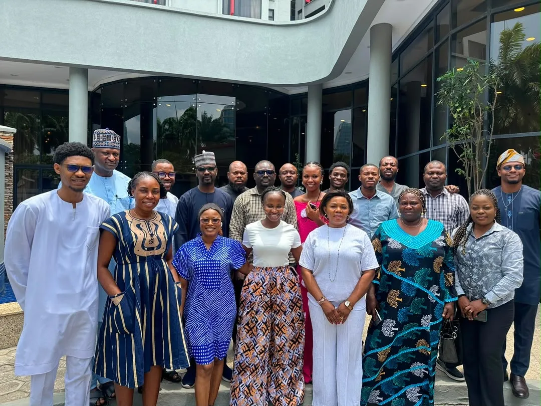 A cohort of around eighteen participants outside the venue after a training session.